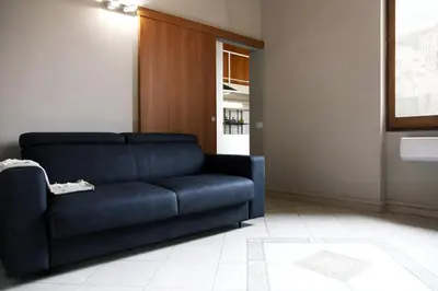 a living room with a blue couch and a kitchen at Rome, very central 2 bedrooms 4 beds in Rome