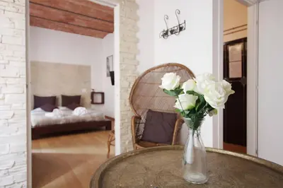 a vase with white roses on a table in a room at Ostilia Loft in Rome