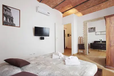 a bedroom with a bed and a tv on the wall at Ostilia Loft in Rome