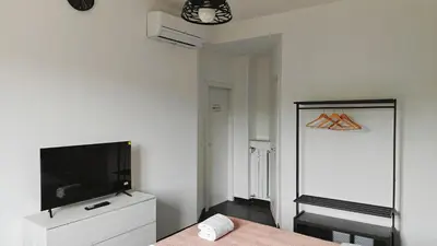 a bedroom with a flat screen tv on a white wall at LIFEI House in Rome