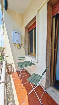 two green chairs and a table on a balcony at LIFEI House in Rome