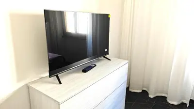 a flat screen tv sitting on top of a white dresser at LIFEI House in Rome