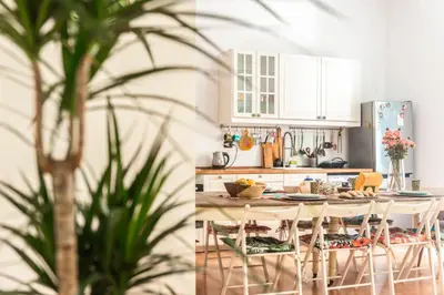 a kitchen with white cabinets and a table with chairs at The Bright Marajà Roma Centro Luxury Boutique Retreat in Rome