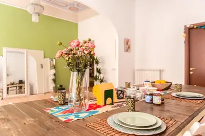 a wooden table with a vase of flowers on it at The Bright Marajà Roma Centro Luxury Boutique Retreat in Rome