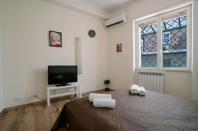 a bedroom with a bed and a tv and a window at Marilyn Rooms in Rome