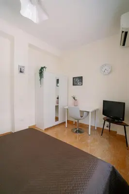 a bedroom with a bed and a table and a television at Marilyn Rooms in Rome