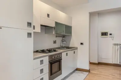 a kitchen with white cabinets and a stove top oven at VaticanRhome I in Rome