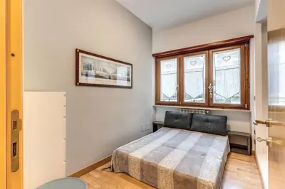 a bedroom with a bed and two windows at VaticanRhome I in Rome