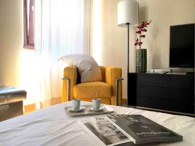 a hotel room with a bed with a chair and a newspaper at Charming in Rome