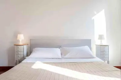 a bedroom with a white bed with two lamps at Romantic in Rome