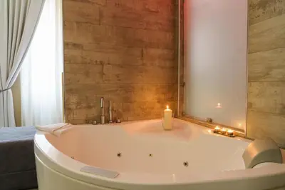 a bath tub with a candle in a bathroom at Corso Boutique Luxury Rooms in Rome
