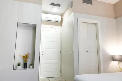 a white bedroom with a bed and a mirror at Corso Boutique Luxury Rooms in Rome