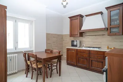 a kitchen with a wooden table and chairs and a table and a stove at Stile e spazio nel cuore di Roma in Rome