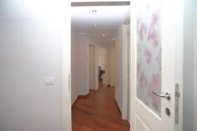 a hallway with white walls and wooden floors and a door at Stile e spazio nel cuore di Roma in Rome