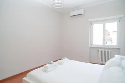 a white bedroom with two beds and a window at Stile e spazio nel cuore di Roma in Rome