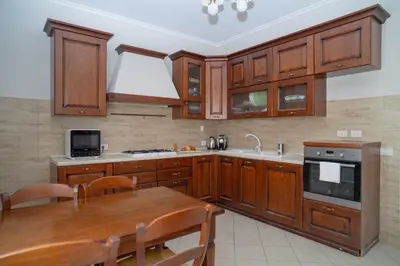 a kitchen with wooden cabinets and a wooden table at Stile e spazio nel cuore di Roma in Rome