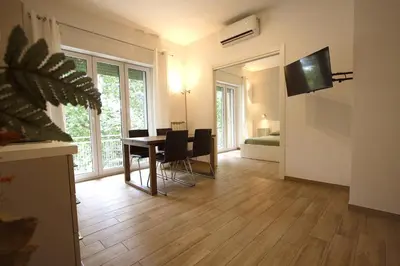 a living room with a table and chairs and a television at Inventori Tevere Suite in Rome