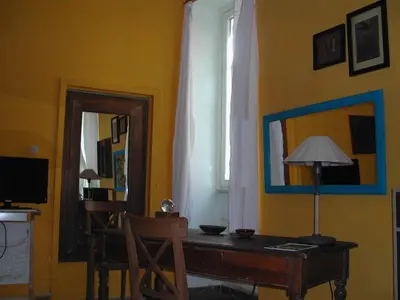 a room with a desk with a lamp and a mirror at Appartamento del Boschetto in Rome