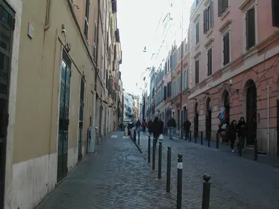 a cobblestone street with people walking down it at Appartamento del Boschetto in Rome