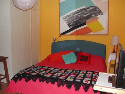 a bedroom with a bed with a red bedspread at Appartamento del Boschetto in Rome