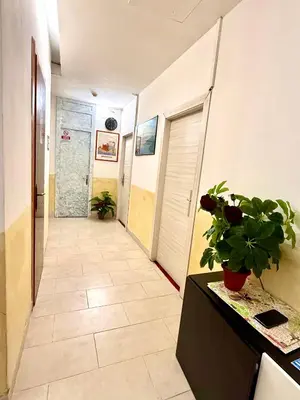 a hallway with a tile floor and a hallway with a plant at Luna Guest House in Rome