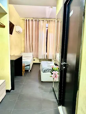 a small room with two beds and a window at Luna Guest House in Rome