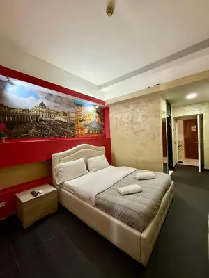 a bedroom with a large bed with a painting on the wall at Luna Guest House in Rome