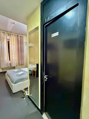 a room with a bed and a black door with a mirror at Luna Guest House in Rome