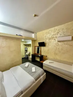 a hotel room with two beds and a desk and a bed sidx sidx sidx sidx at Luna Guest House in Rome