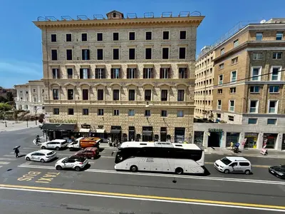 a city street with cars and a bus in front of buildings at Luna Guest House in Rome