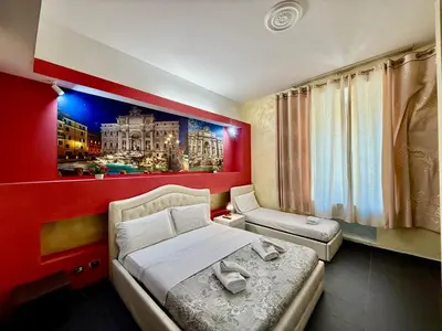 a bedroom with a large bed and a red wall at Luna Guest House in Rome
