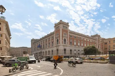 a large building with cars and people crossing a street at Appartamento Campo Marzio Lusso in Rome