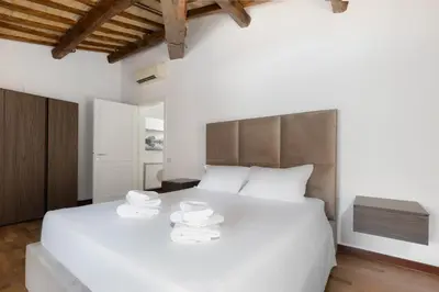 a bedroom with a large white bed with towels on it at Appartamento Campo Marzio Lusso in Rome
