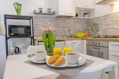 a kitchen with two cups of coffee and croissants on a table at Open Space Moderno a 20 Minuti dal Colosseo vicino alla Metro A e C in Rome