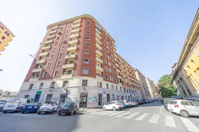 a tall building on a city street with cars parked at Open Space Moderno a 20 Minuti dal Colosseo vicino alla Metro A e C in Rome