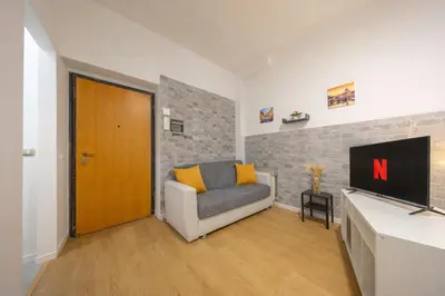 a living room with a couch and a television at Open Space Moderno a 20 Minuti dal Colosseo vicino alla Metro A e C in Rome