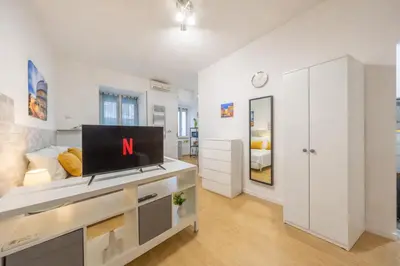 a living room with a desk with a television on it at Open Space Moderno a 20 Minuti dal Colosseo vicino alla Metro A e C in Rome
