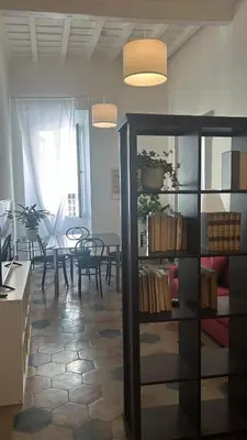 a living room with a table and a book shelf at Colosseo Promenade in Rome