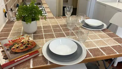 a table with plates and glasses and a pizza on it at Colosseo Promenade in Rome
