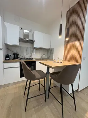 a kitchen with a wooden table and two chairs at Gianvenuti House Rome - Metro A with Jacuzzi in Rome