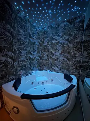 a bathroom with a bath tub with lights on the wall at Gianvenuti House Rome - Metro A with Jacuzzi in Rome