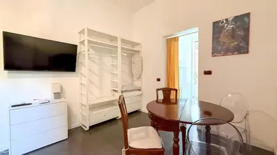 a dining room with a table and a tv in a room at Beautiful apartment within walking distance of the Vatican in Rome
