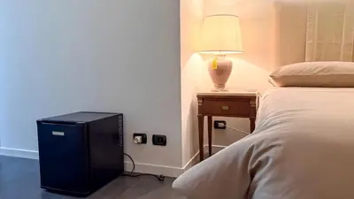 a bedroom with a bed and a lamp on a night stand at Beautiful apartment within walking distance of the Vatican in Rome