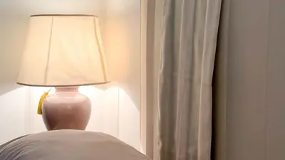 a lamp sitting on top of a bed next to a window at Beautiful apartment within walking distance of the Vatican in Rome