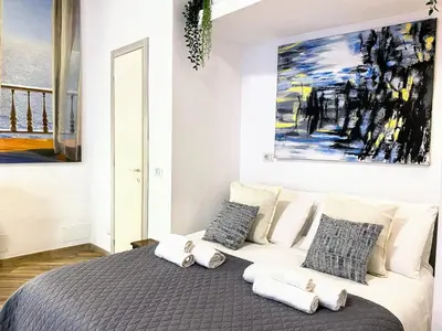 a bedroom with a bed with pillows and a painting at Karma Trastevere Loft in Rome