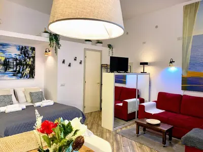 a living room with a bed and a red couch at Karma Trastevere Loft in Rome