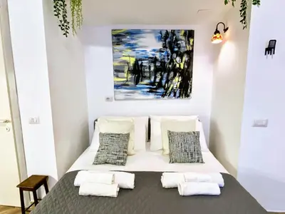 a bed in a room with a painting on the wall at Karma Trastevere Loft in Rome