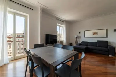 a living room with a table and chairs and a couch at GuestHost - Bright Apartment in Metro San Giovanni in Rome
