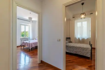 a hallway leading to a bedroom with a bed and a mirror at GuestHost - Bright Apartment in Metro San Giovanni in Rome