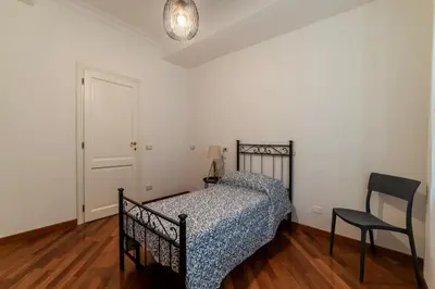 a bedroom with a bed and a chair in it at GuestHost - Bright Apartment in Metro San Giovanni in Rome